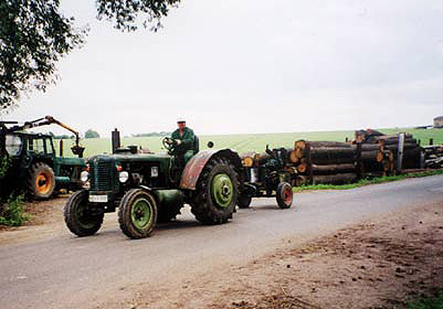 Traktor auf Straße mit Baumstämmen